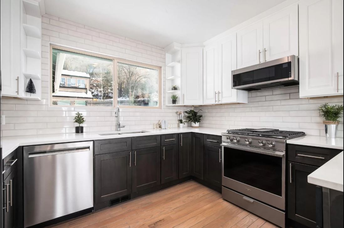 White upper cabinets over espresso shaker base cabinets with subway tile and stainless appliances